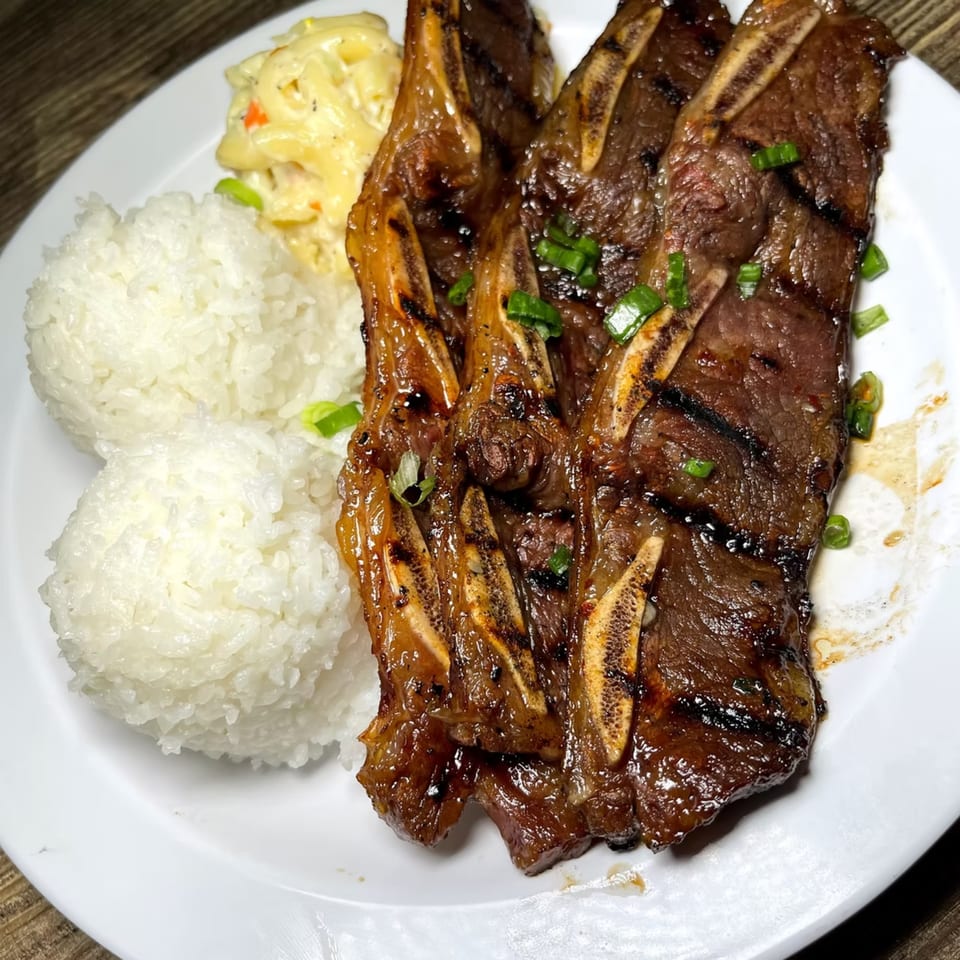 Island Flavor's Hawaiian BBQ short ribs with rice and macaroni salad on a white plate.